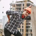 Construction Worker In Protective Helmet Feeling Back Pain