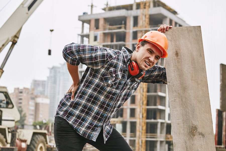 Construction Worker In Protective Helmet Feeling Back Pain