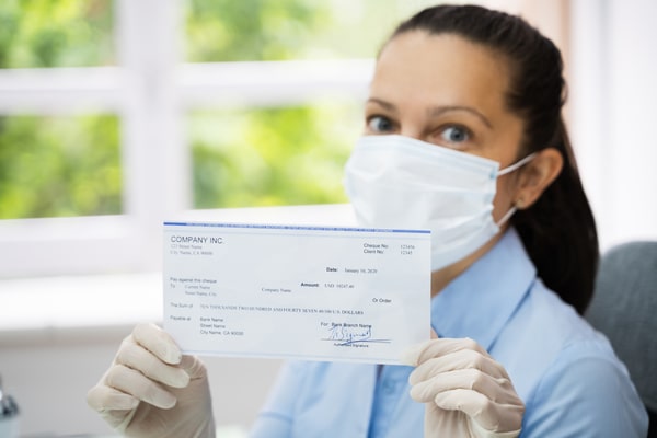 Woman-In-Face-Mask-Holding-Paycheck-
