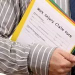 Man holding work injury claim form