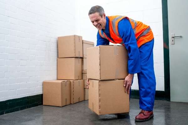 Man incorrectly lifting boxes at work