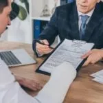 worker's-compensation-claim-to-worker-with-broken-arm-at-table-in-office