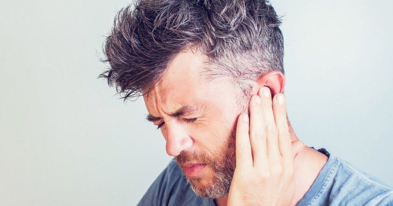 A man who is suffering from tinnitus because of his work.